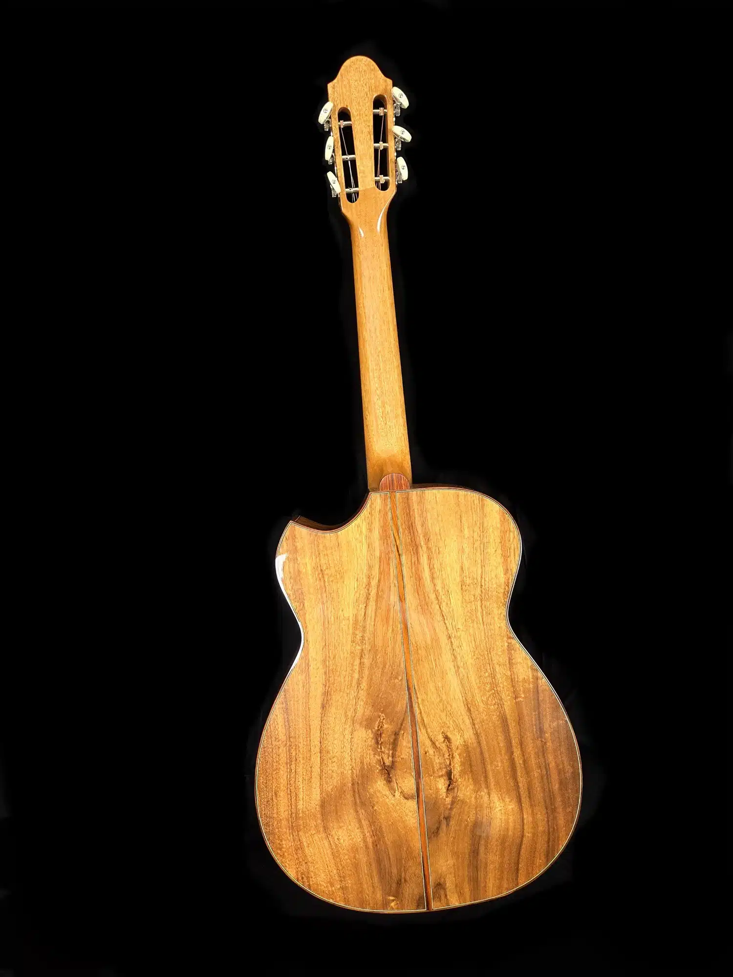 Full back view of a classical acoustic guitar with natural wood grain and slotted headstock.