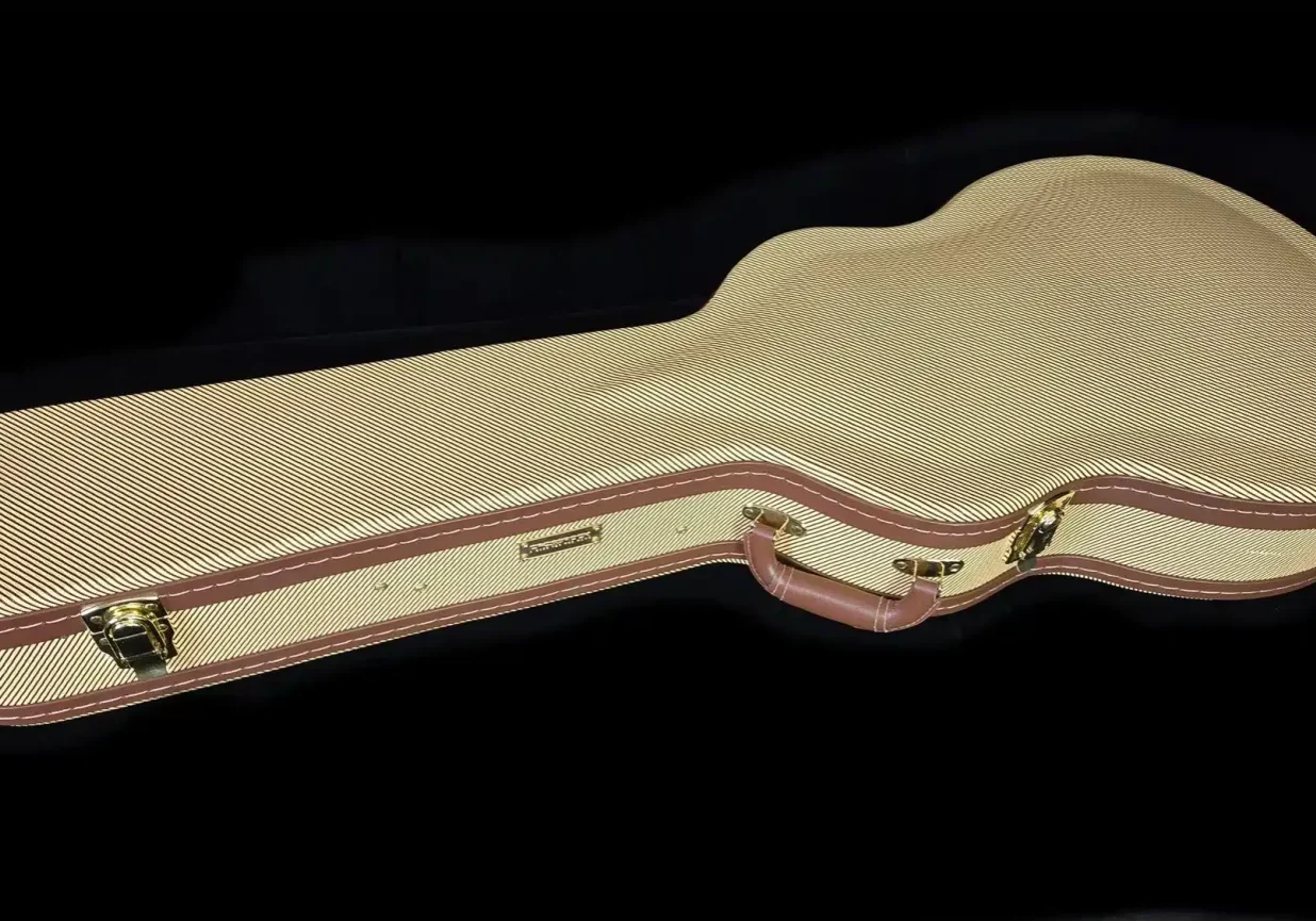 Closed guitar hard case with textured exterior, brown trim, and carrying handle.