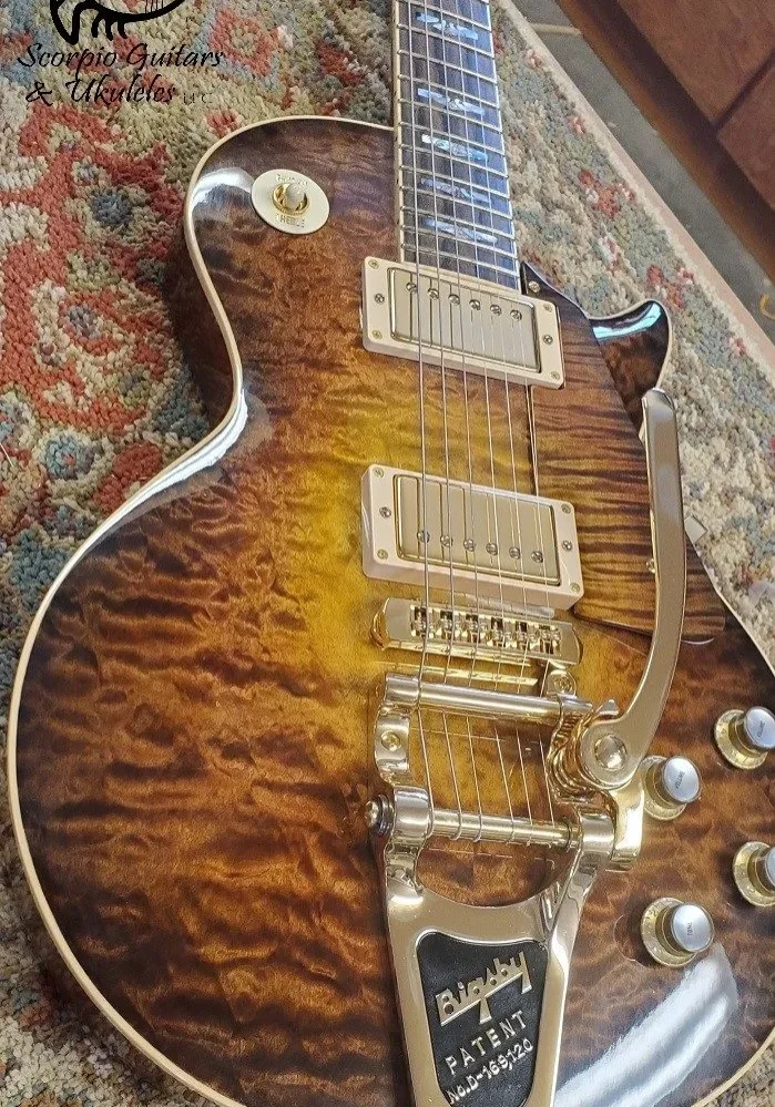 Electric guitar with quilted wood top, dual pickups, metal bridge, and tremolo arm.