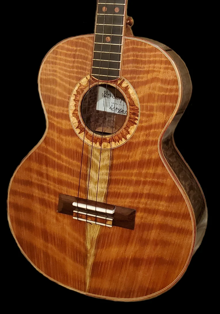 Front view of a custom ukulele with a flamed wood top, decorative rosette, and dark fingerboard.