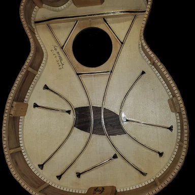 Interior view of a ukulele showing spruce soundboard bracing and central sound hole.