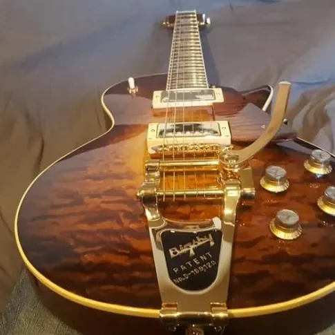 Top view of a custom electric guitar showing quilted maple top and Bigsby-style tremolo