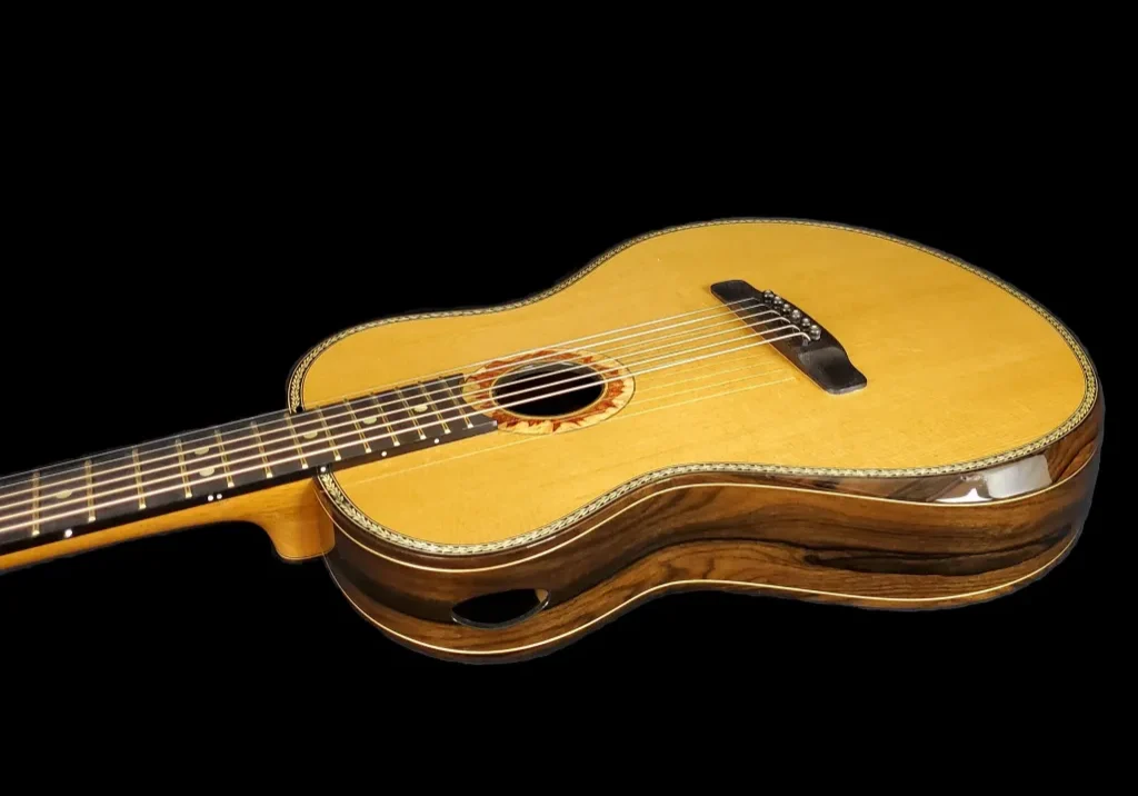 Angled view of a handcrafted acoustic guitar with layered wood sides and side sound port