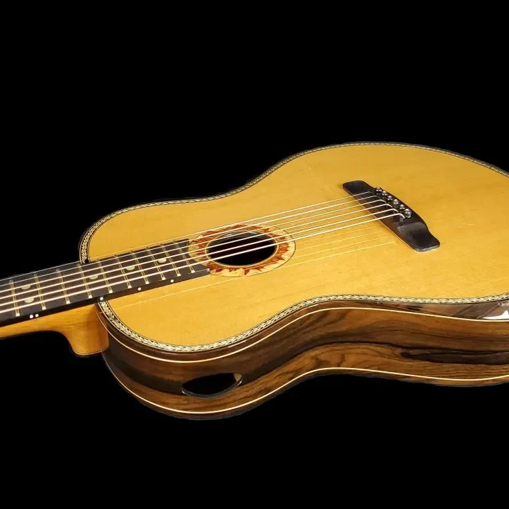 Angled view of a custom ukulele with a light wood top, decorative rosette, dark bridge, and side sound port.